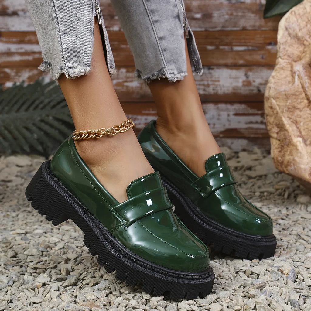 Women's plus size black slip-on loafers with a chunky platform heel and mid-top design.
