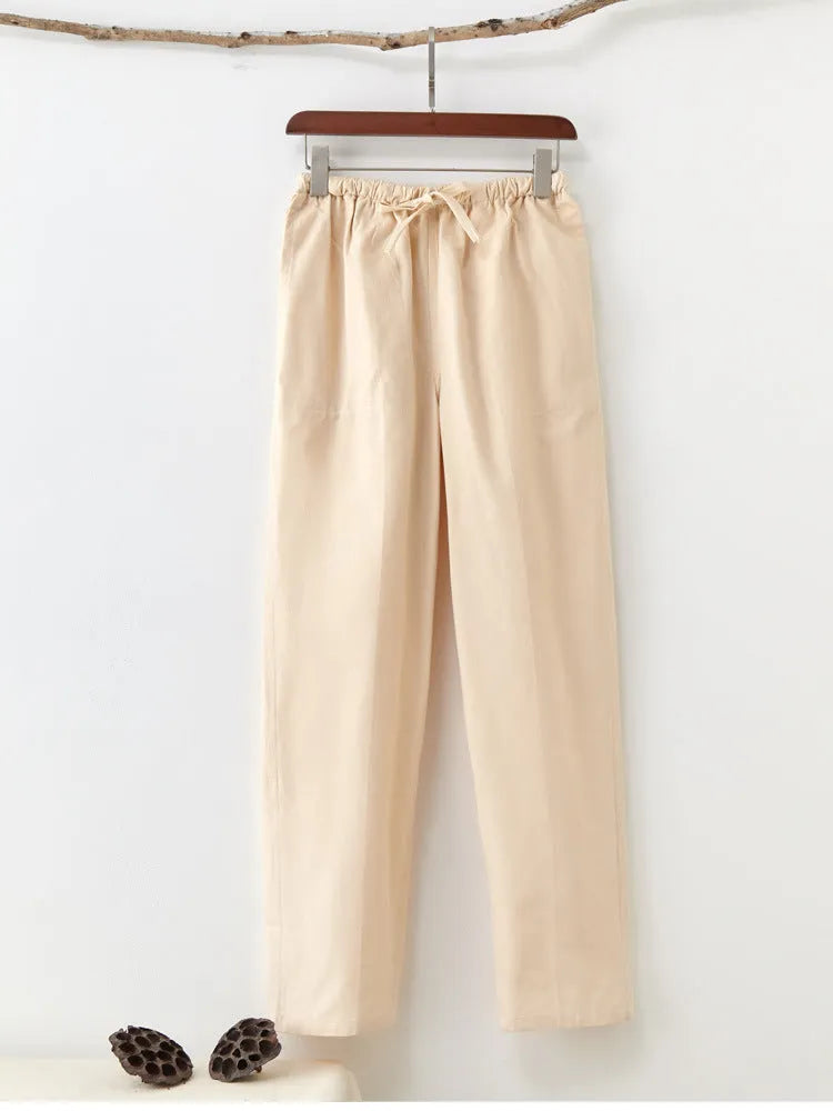 Men's beige pure cotton casual trousers with a drawstring waist on a hanger.