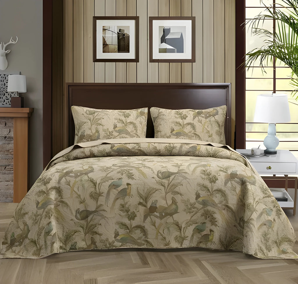 Blue American floral and bird pattern quilted cotton bedspread laid flat on a bed.