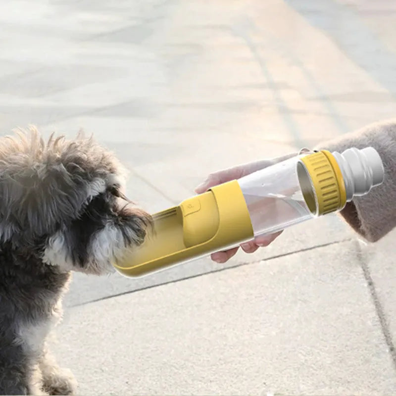 Portable dark blue dog water bottle with built-in bowl, showing one-hand operation.