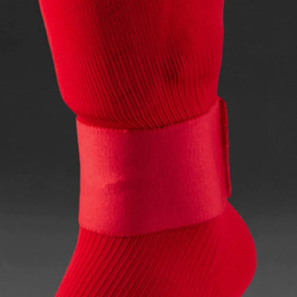 Rubber shin guard strap for football, shown in one of four colours: black, blue, red, or white.
