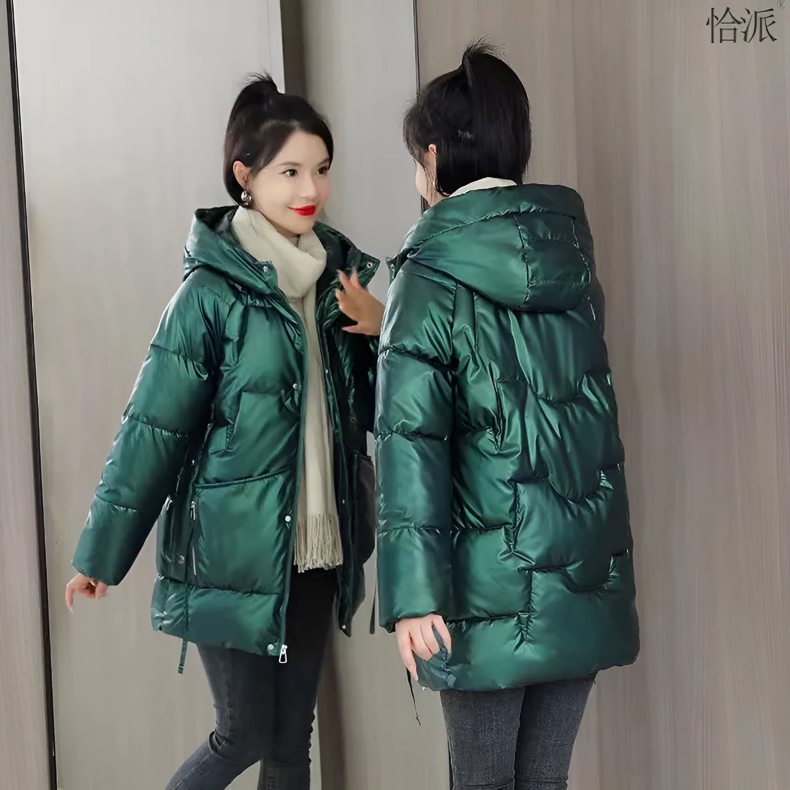Green loose-fit hooded women's winter jacket on a hanger, showing long sleeves.