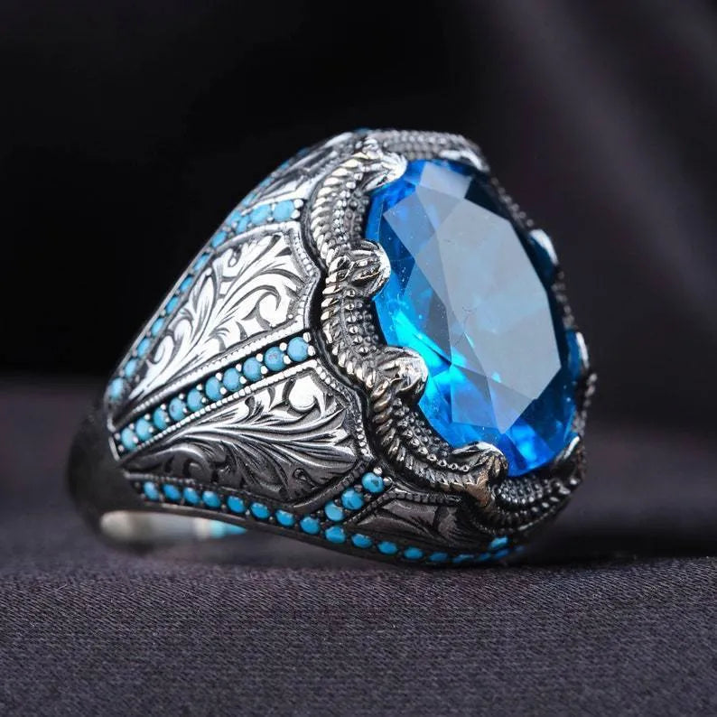 Geometric antique silver alloy couple ring with a blue zircon stone in a Grandmother Diamond setting.