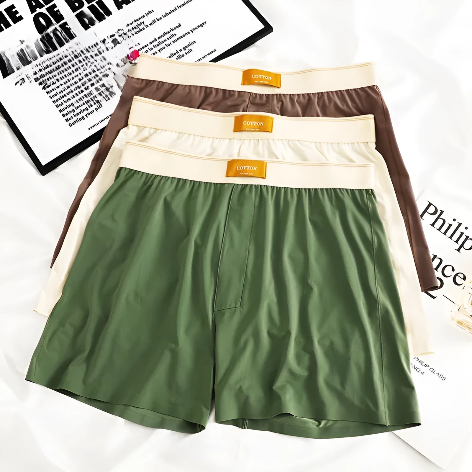 Pack of three men's solid colour loose fit ice silk boxer shorts on a white background