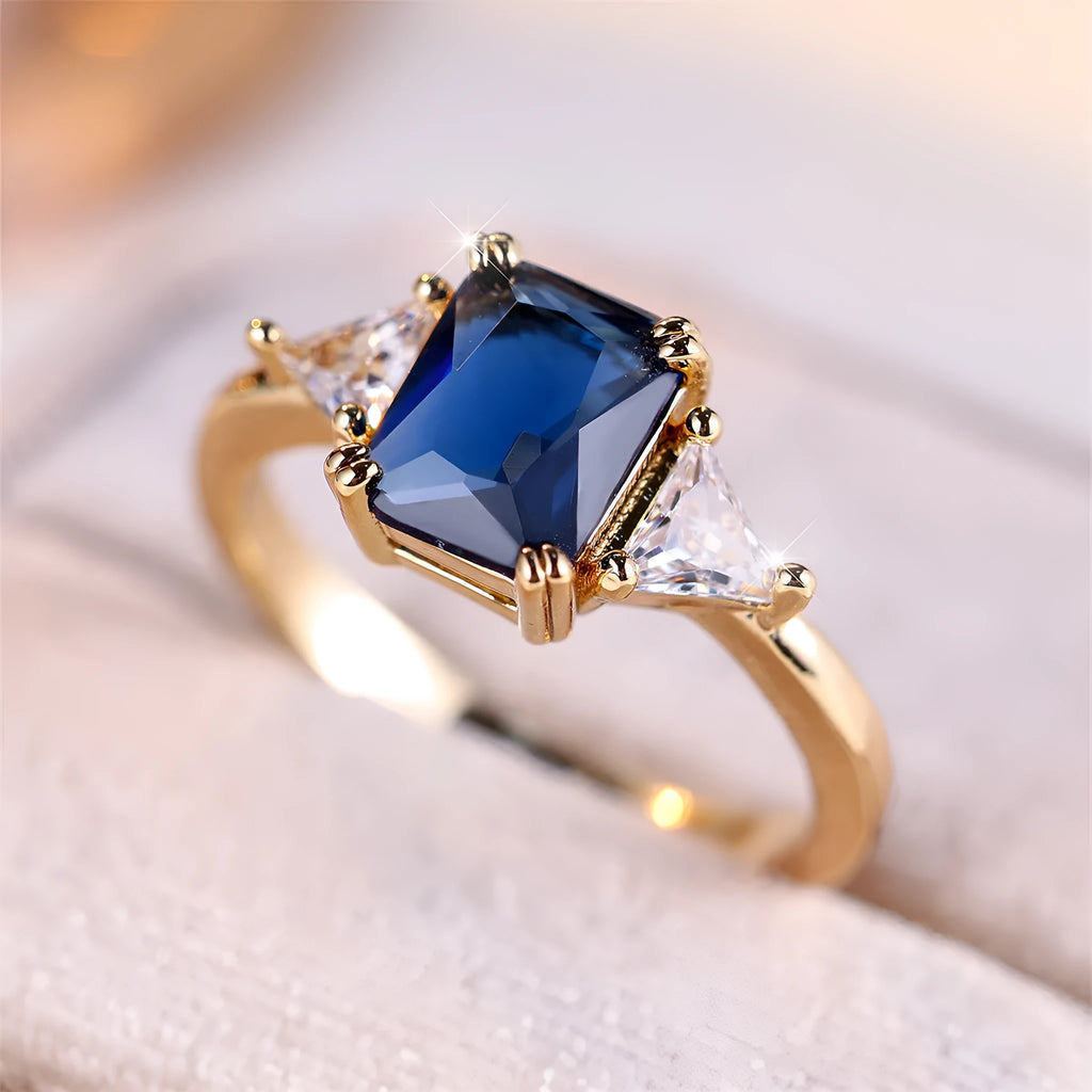 Rectangular copper ring with gold sapphire blue finish shown on model finger