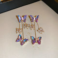 A pair of silver needle crystal flower and butterfly tassel earrings in a blue purple electroplated colour.