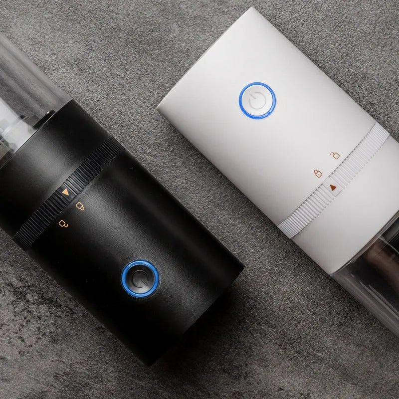 Black portable electric coffee grinder with transparent chamber showing coffee beans, USB-C charging port visible