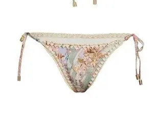 Women's creamy white floral bikini set with top, briefs, and removable skirt on beach background