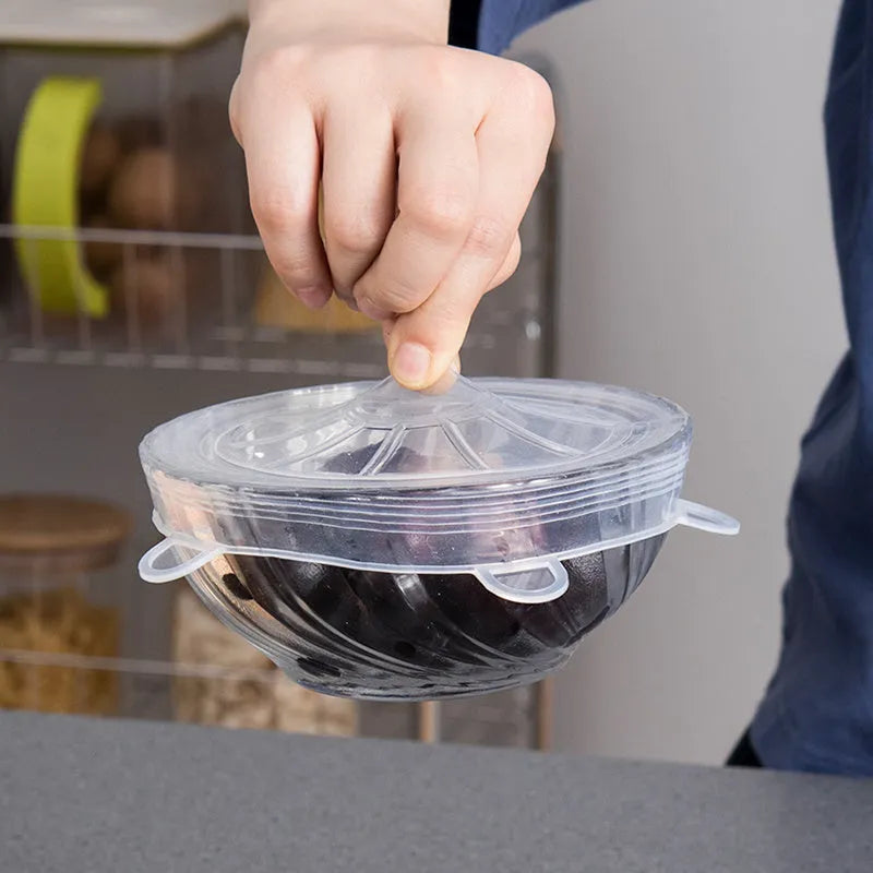 Set of six colourful silicone stretch food covers in different sizes on a kitchen counter.