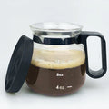 Transparent borosilicate glass coffee maker with black silicone cover on a stovetop