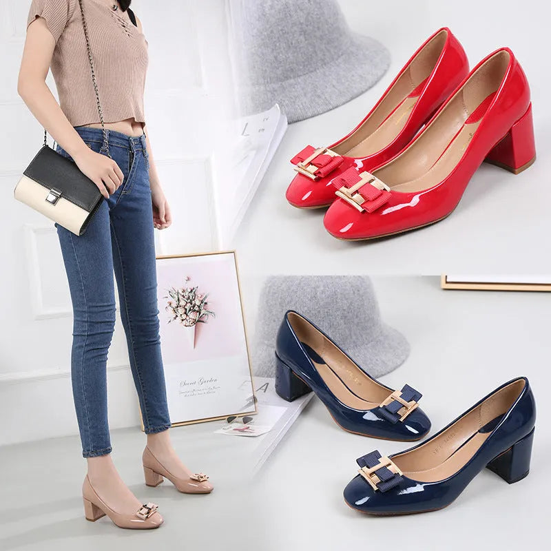 Mid heel round toe chunky heel pumps in solid colour with work buckle detail on a white background