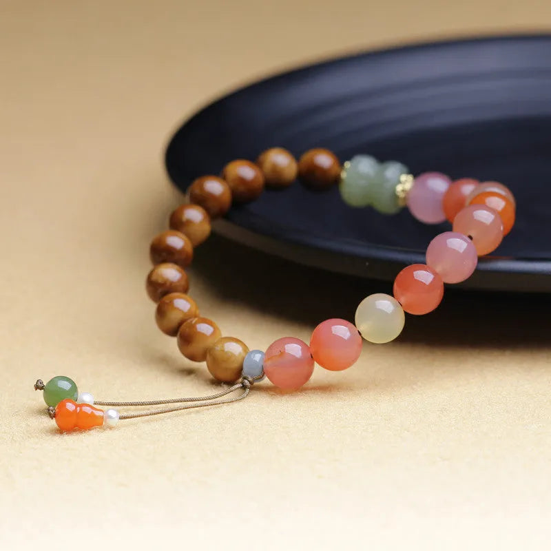 Women's agate bracelet with 8mm diamond-shaped persimmon-coloured beads on a wrist.
