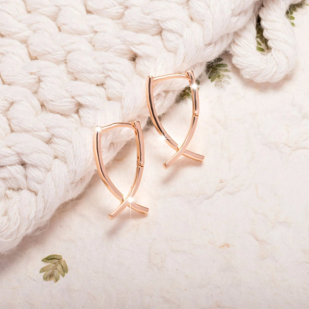Rose gold coloured cross shaped earrings for women made from copper.