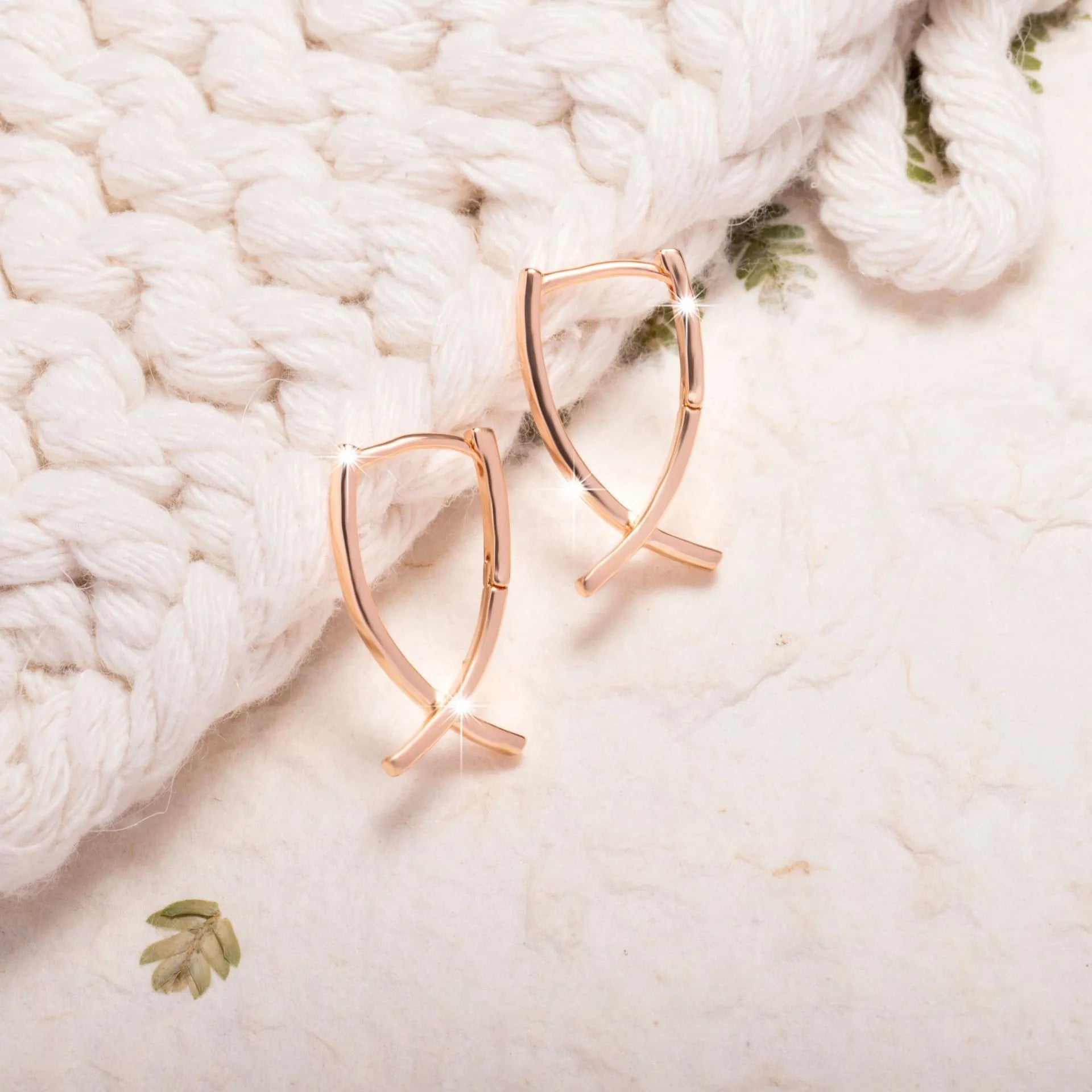 Rose gold coloured cross shaped earrings for women made from copper.