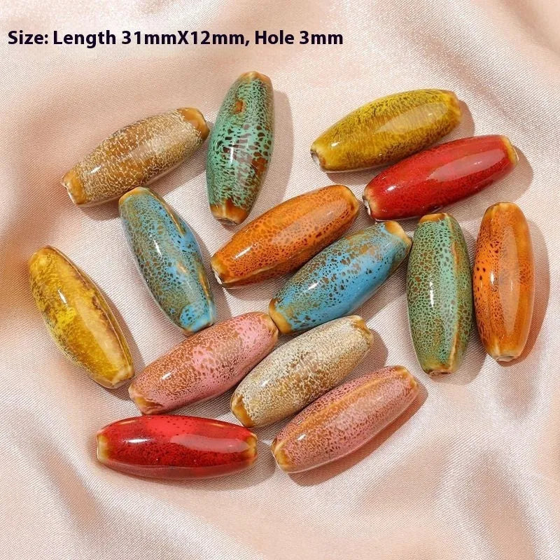 Ten ceramic bullet beads with a glazed finish arranged together, showing assorted colour options.