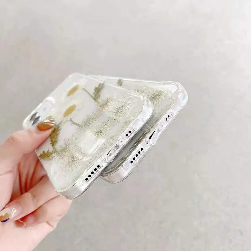White TPU iPhone case with epoxy daisy floral design on back, shown fitted to a phone