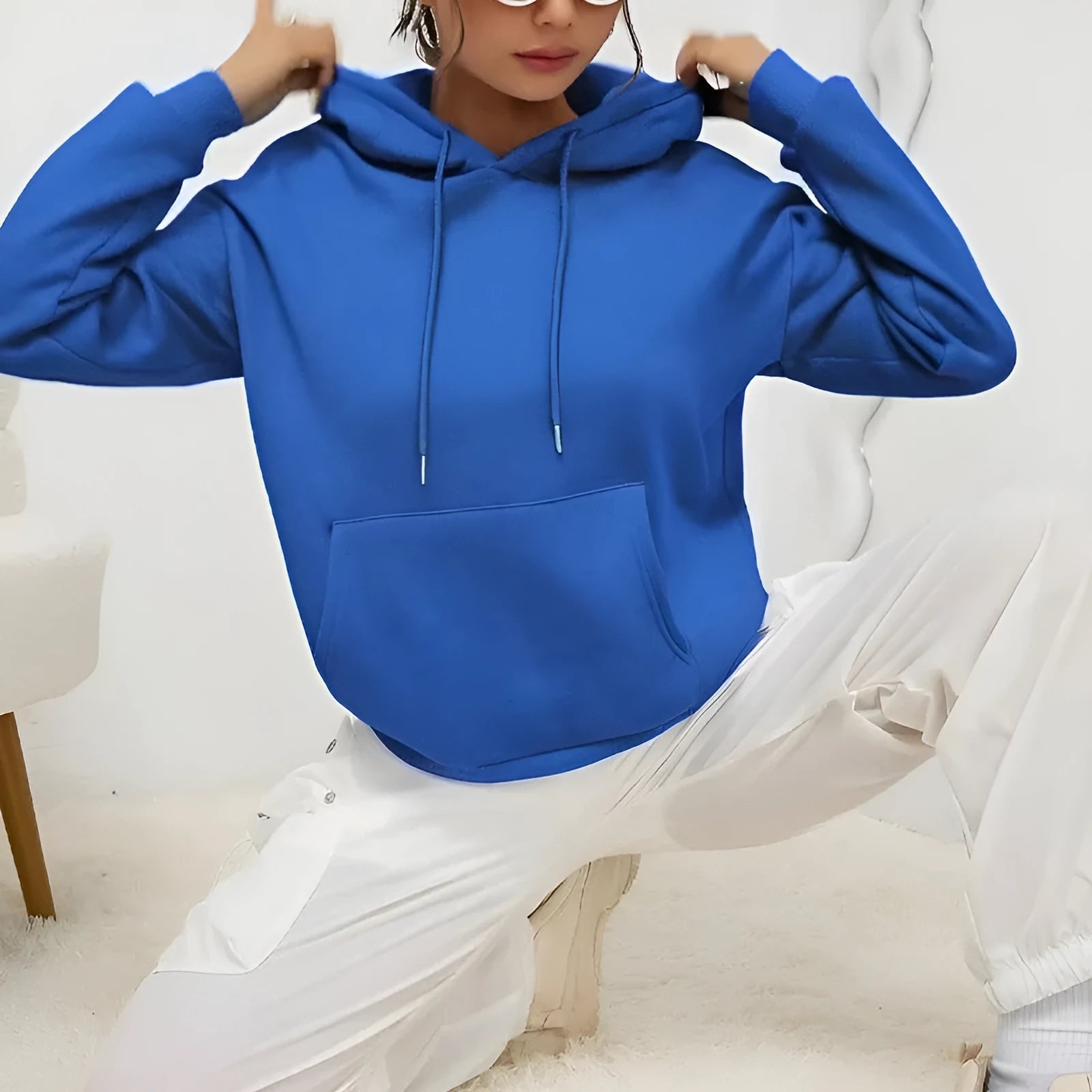 Women's loose fit grey sweatshirt with a drawstring pocket and long sleeves on a hanger.