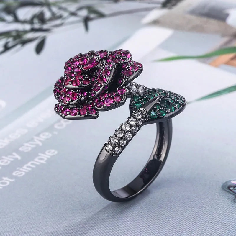 Geometric black gold ring with red simulated corundum centrepiece in flower design
