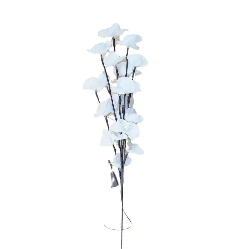 Pink LED orchid branch decorative light on a bedside table.