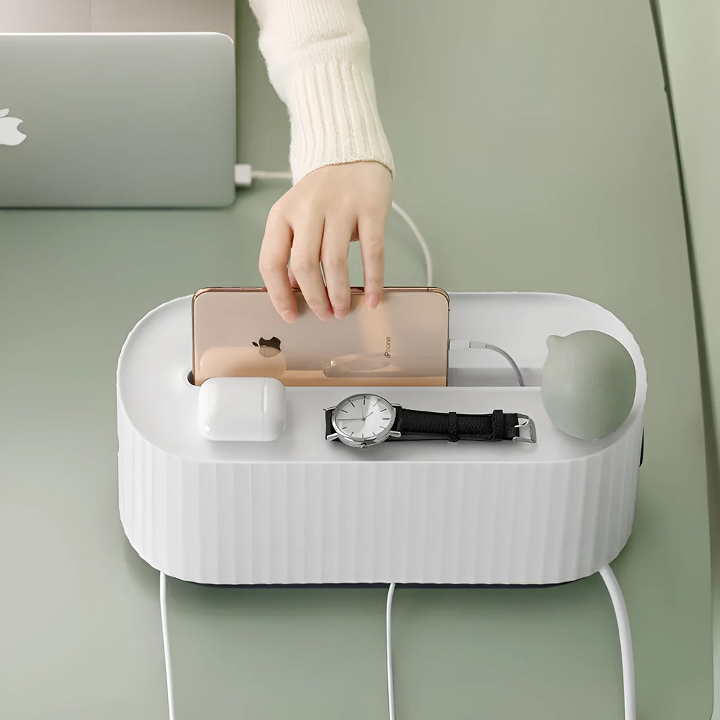 Blue and white plastic cable management box for power strips with lid open showing phone slot and cable holes