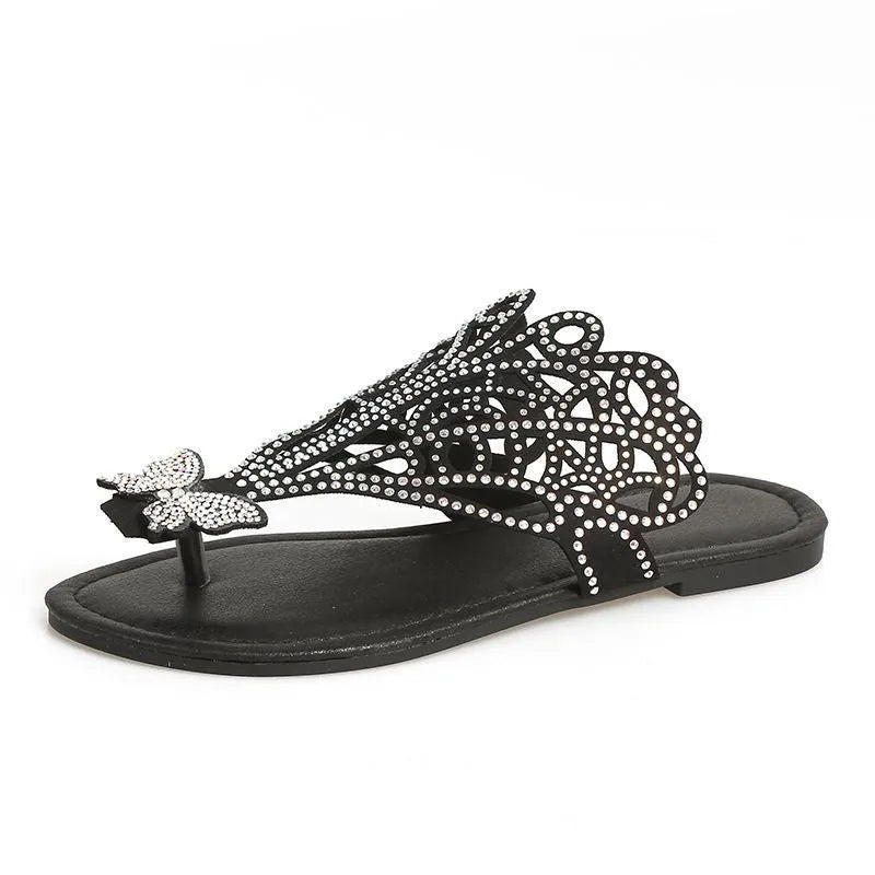 Women's black flip-toe sandals with rhinestone decorations and a hollow out design on a gold background.