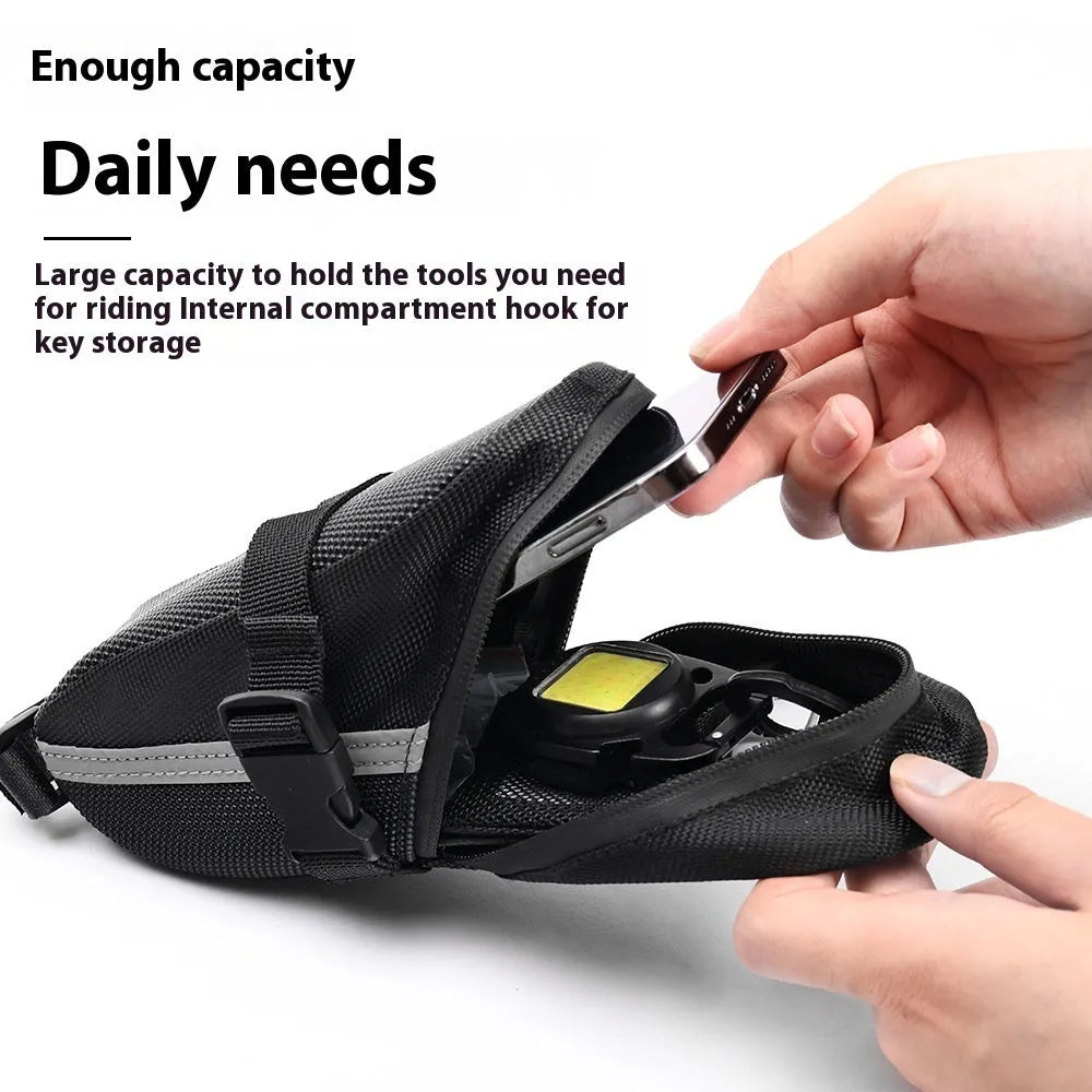 Black cycling tail bag mounted on mountain bike saddle with quick release fixture