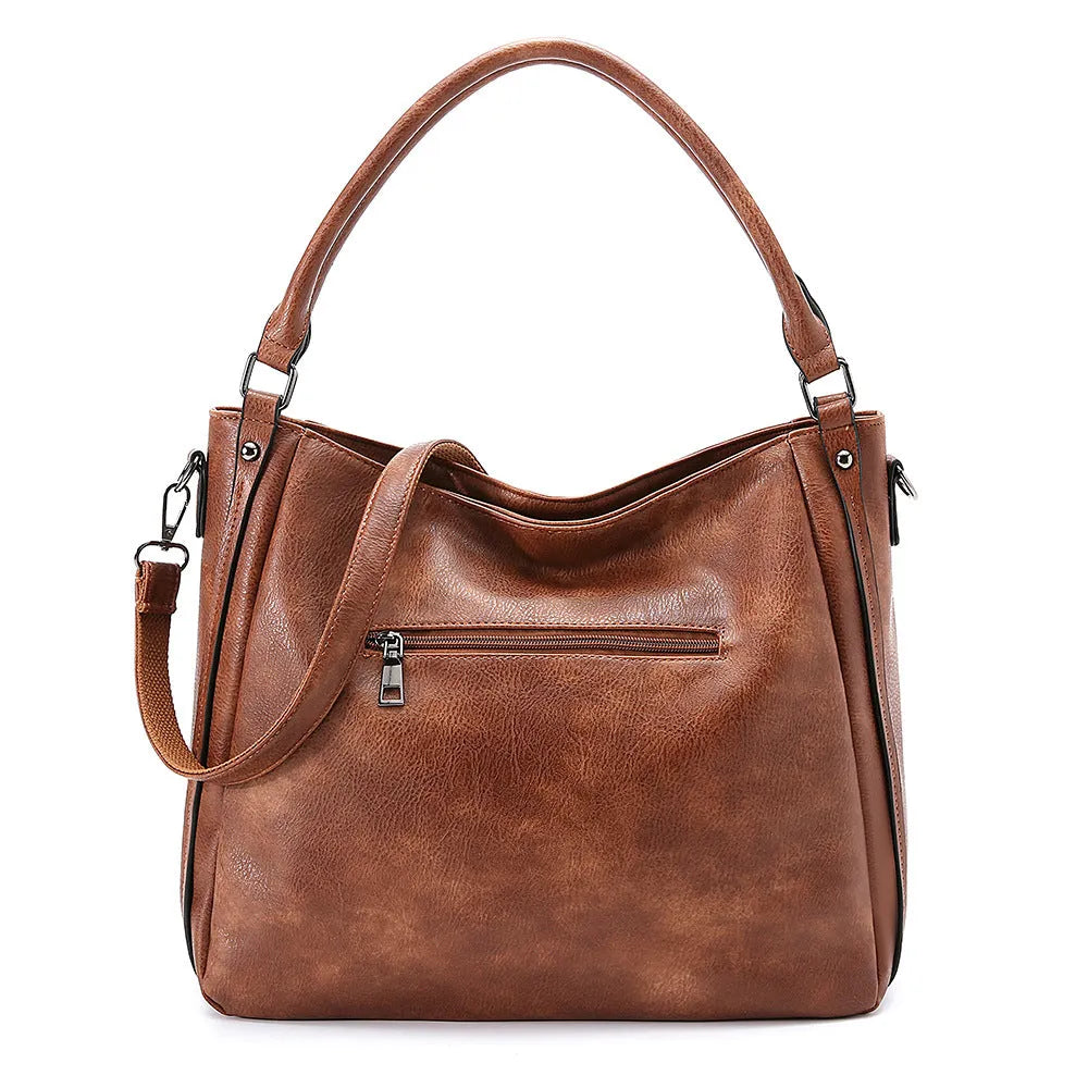 Soft PU crossbody shoulder bag in khaki with metal accent and double strap connectors on a white background