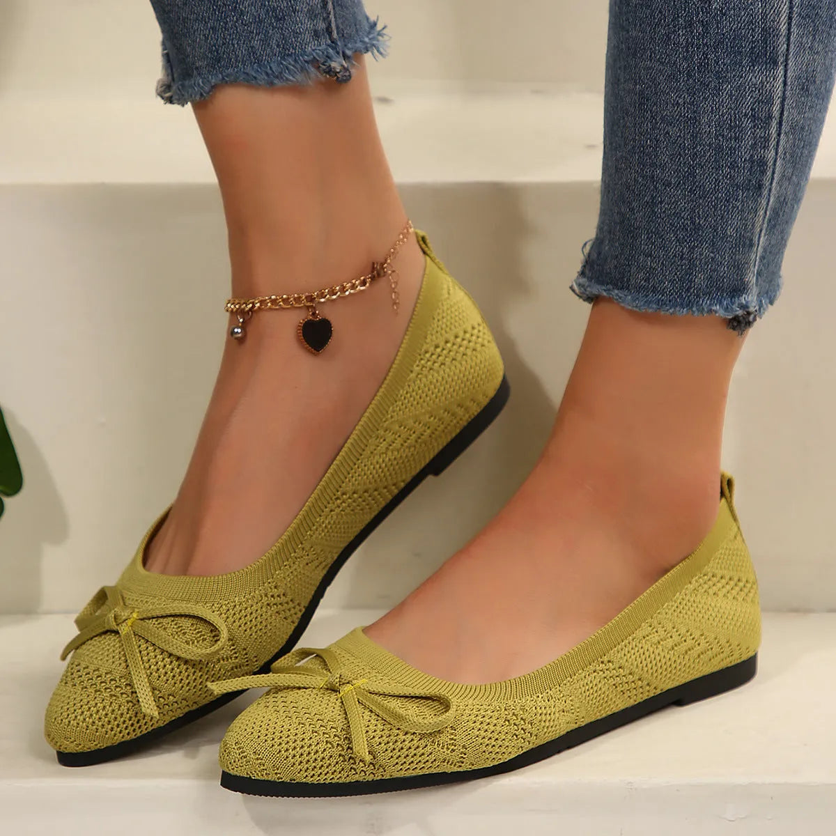Women's knitted flat shoes with a pointed toe and decorative bow, shown in multiple colour options.