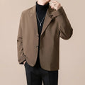 Man wearing a loose fit apricot coloured casual suit jacket with long sleeves.