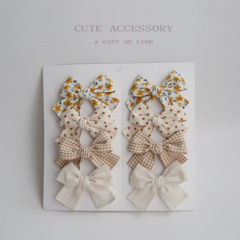Dovetail bow hairclips for children in multiple colour patterns including beige grid dots and blue flowers