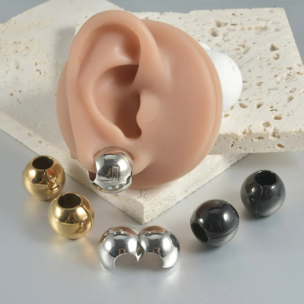 Stainless steel hollow geometric earrings combining a skull with a Buddha head motif.