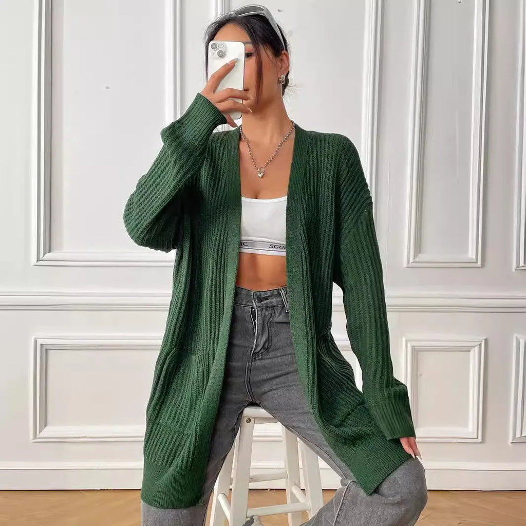A woman's loose-fit acrylic cardigan in dark green with long sleeves and two front pockets.
