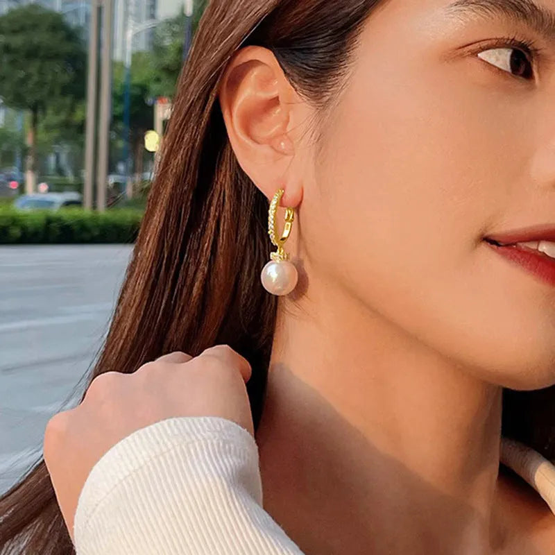 Yellow gold tone geometric earrings with imitation pearl and zircon inlay, round and ring design, one pair.