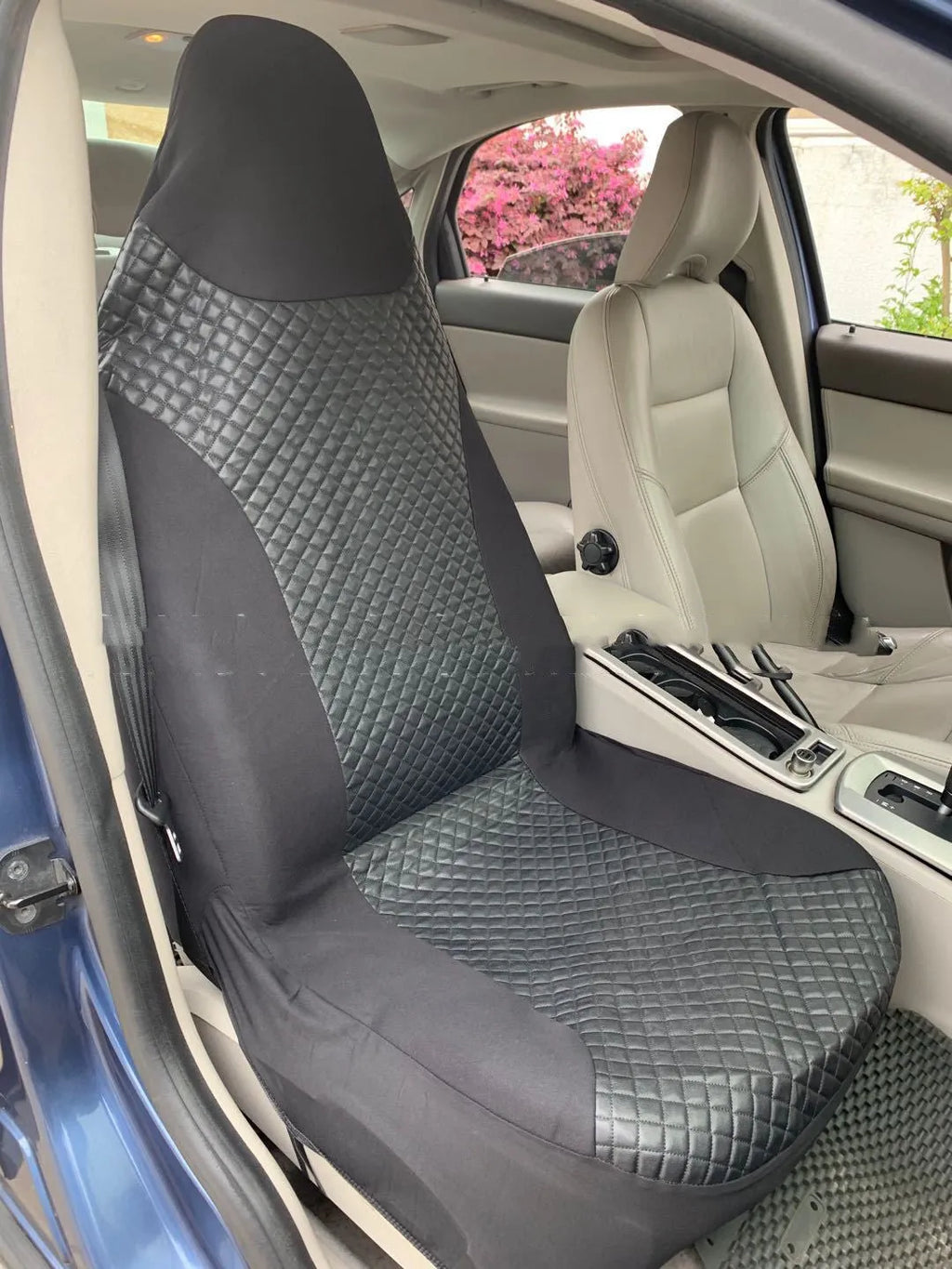 Black quilted automotive seat cover showing dimensional stitching pattern and plastic installation hooks