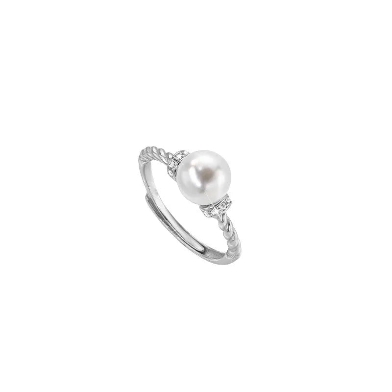 Geometric antique twist ring with a central pearl, on an adjustable copper band in gold colour.