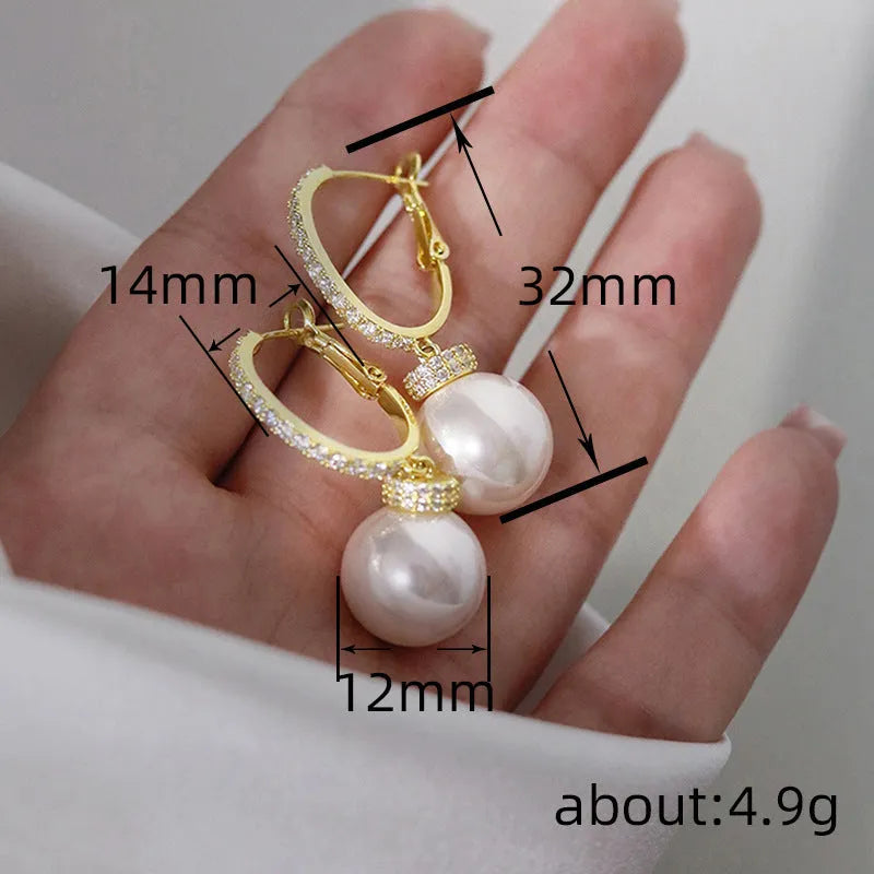Yellow gold tone geometric earrings with imitation pearl and zircon inlay, round and ring design, one pair.
