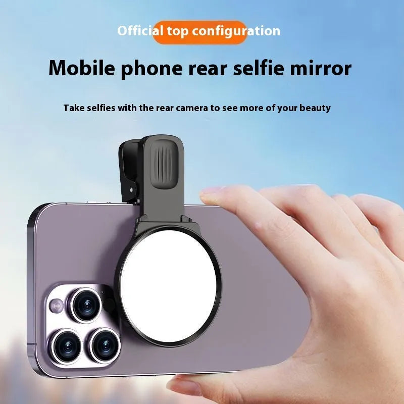 Black mobile phone rear camera self-timer mirror clip with plastic and glass construction, shown attached to a phone.