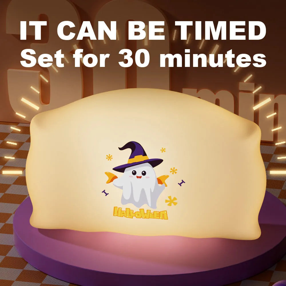 Cartoon Halloween ghost doll table lamp with warm LED light on a bedside table.