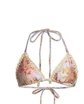 Women's creamy white floral bikini set with top, briefs, and removable skirt on beach background