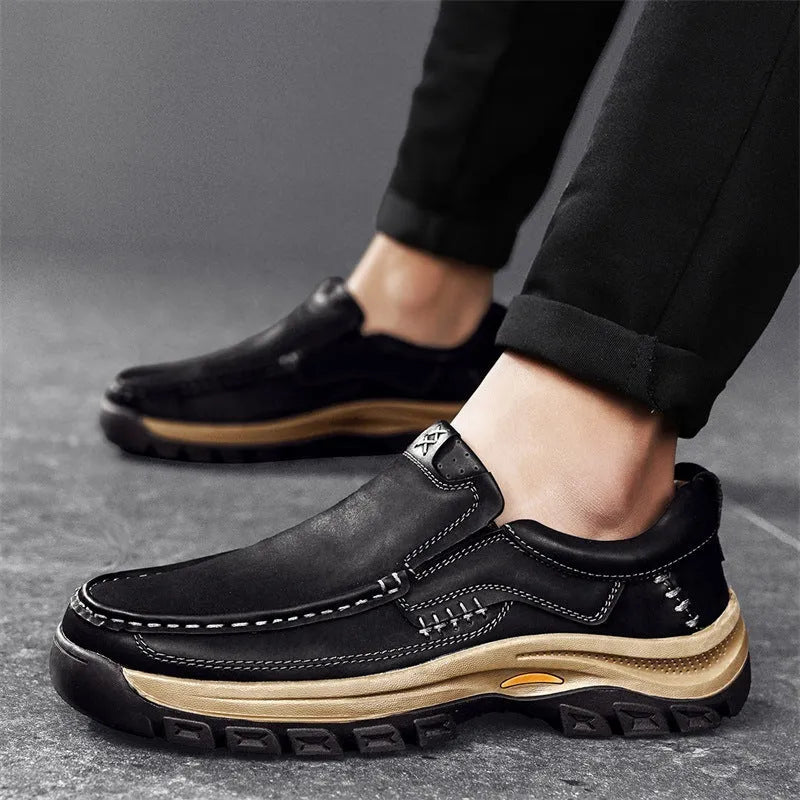 Men's black leather shoes with thick rubber soles and round toe design showing visible sewing thread construction
