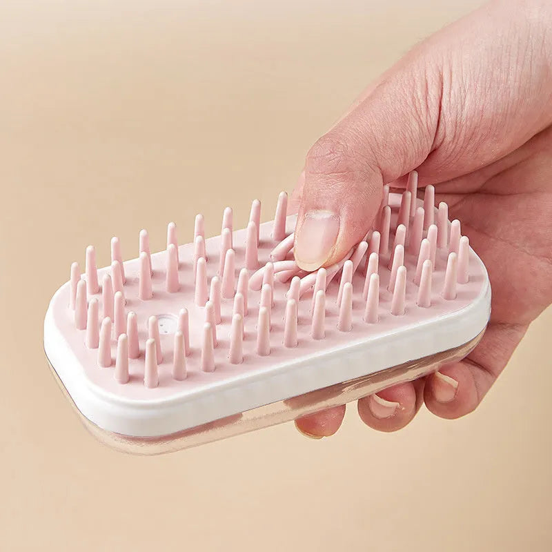 Grey silicone pet bath brush with a long handle next to a pink one, showing soft bristles for washing dogs and cats.