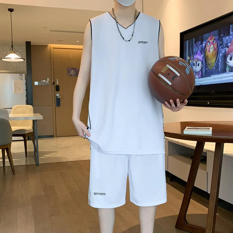 Man wearing a grey sleeveless polyester vest and matching shorts basketball sports set.