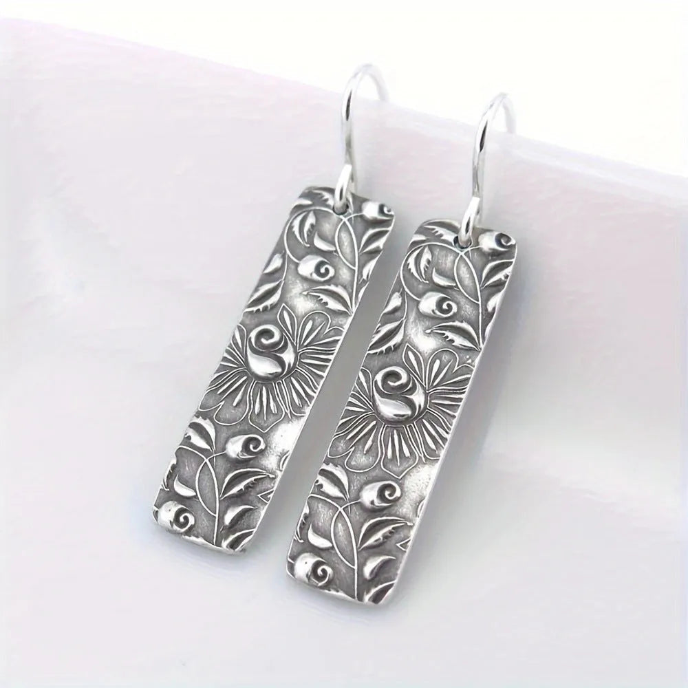 Silver geometric long earrings with a carved vine pattern in a retro style