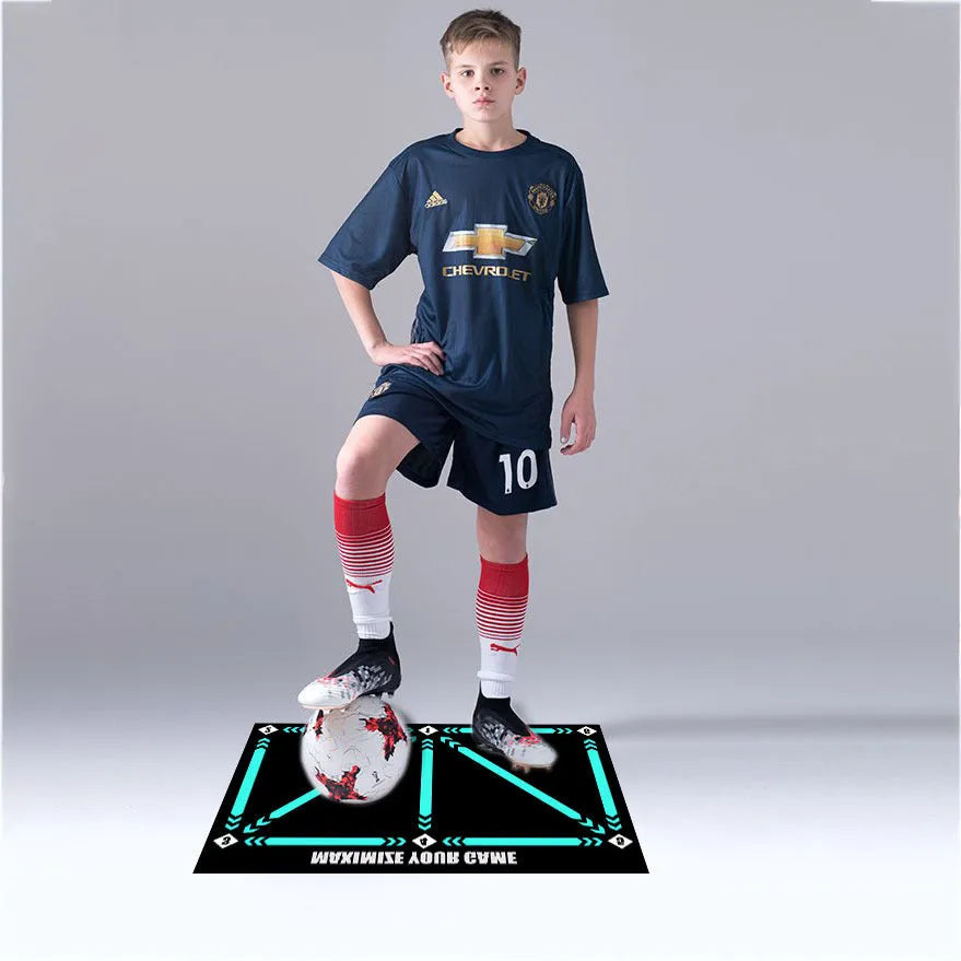 Black rectangular football training mat measuring 60 by 90 cm on a grass surface.
