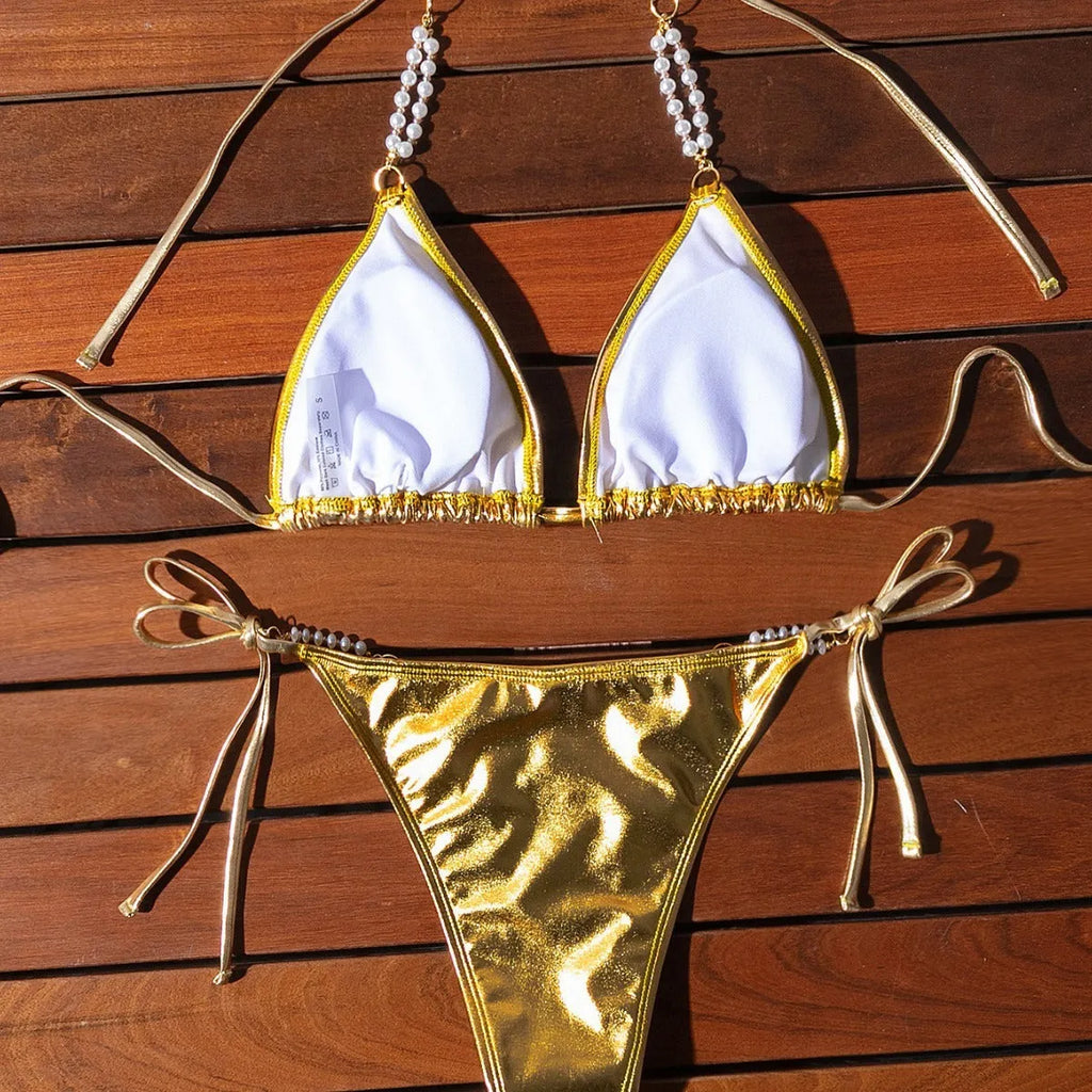 Gold bronzing effect women's halter neck bikini with lace-up back and pearl chain detail on mannequin
