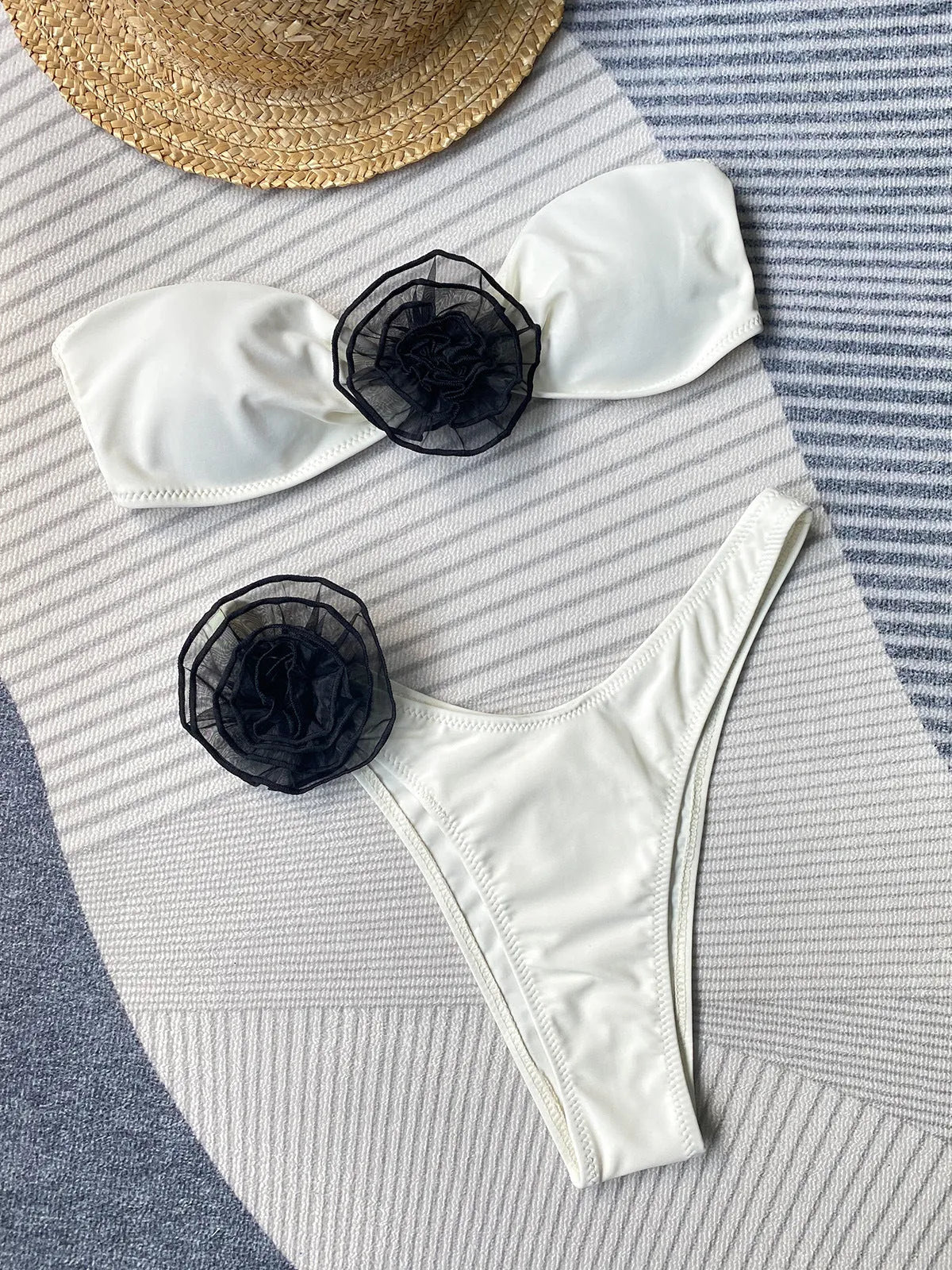 Women's black cross-back bikini with floral split detail and matching shorts.