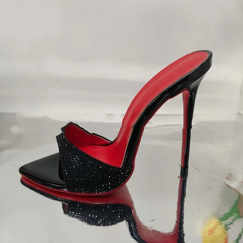 Black rhinestone ankle-strap open toe sandal with super high heel and pointed toe on white background
