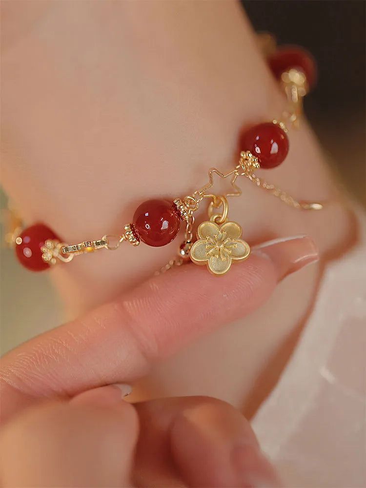 Close-up of a red agate double layer women's bracelet with floral and peach blossom motifs.