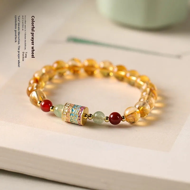 Yellow citrine prayer wheel bracelet with 8mm beads on wrist