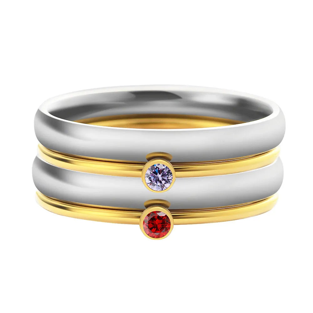 December birthstone engraved geometric ring in titanium steel with gold accents, shown on a finger.